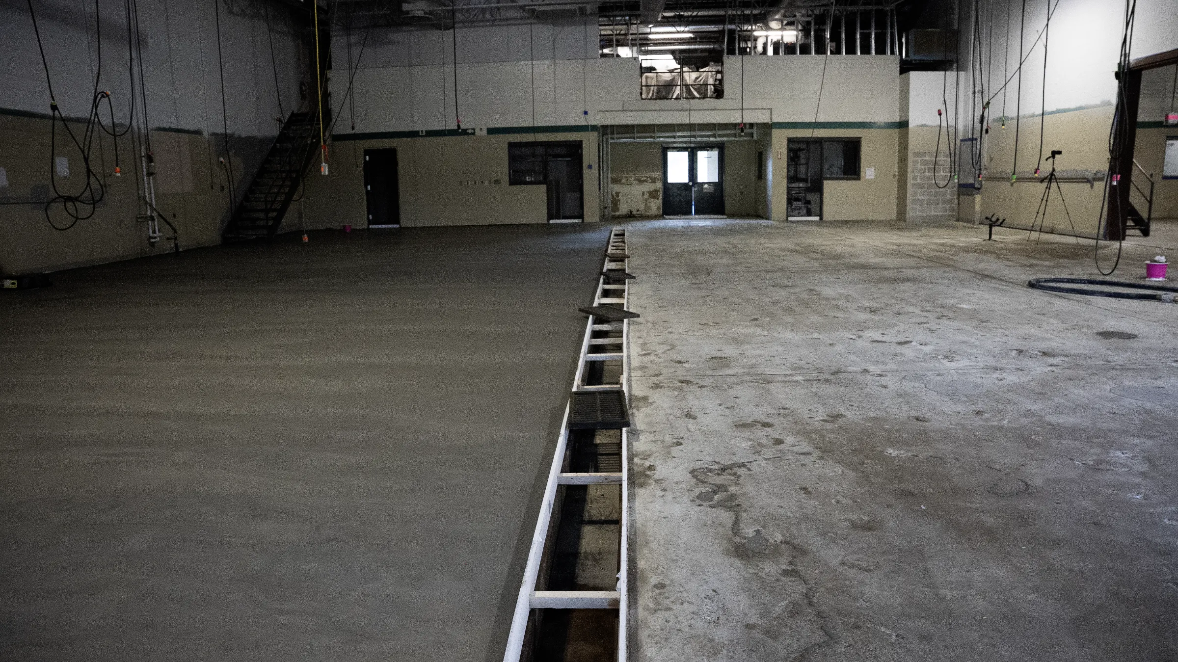 Newly poured commercial floor beside the prepared concrete substrate