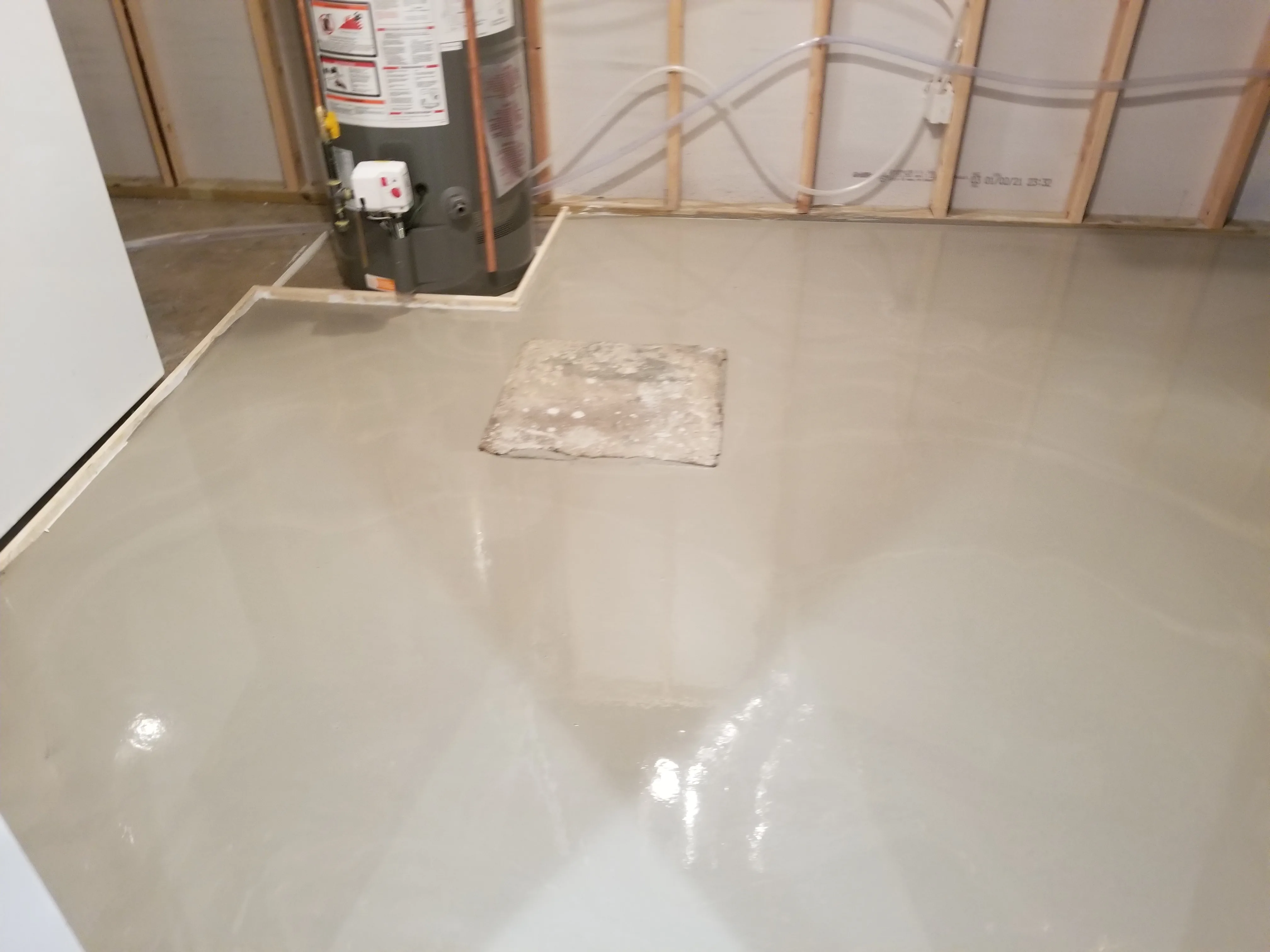 Finished concrete underlayment around basement utilities