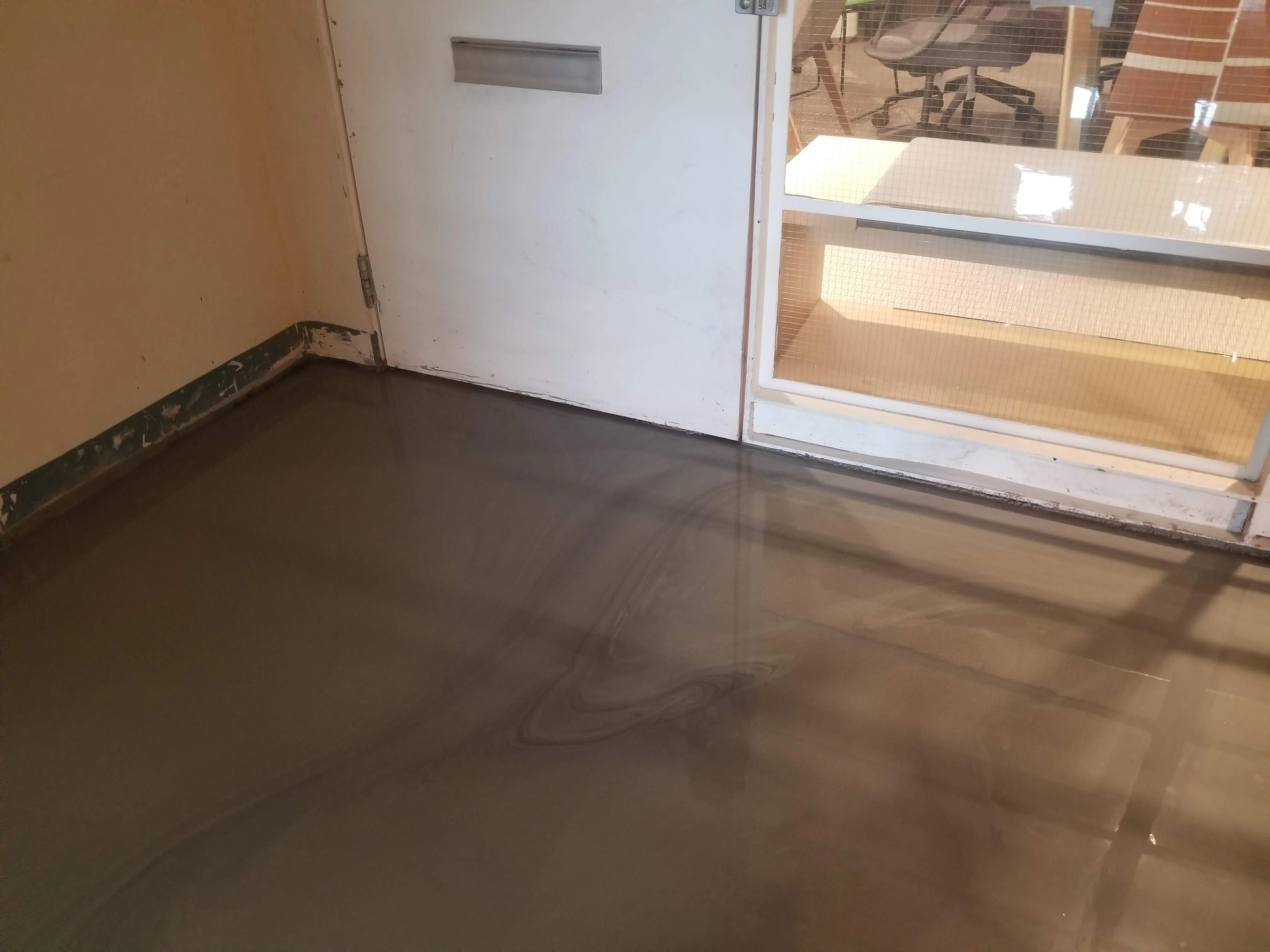 Finished self-leveling underlayment at a commercial doorway