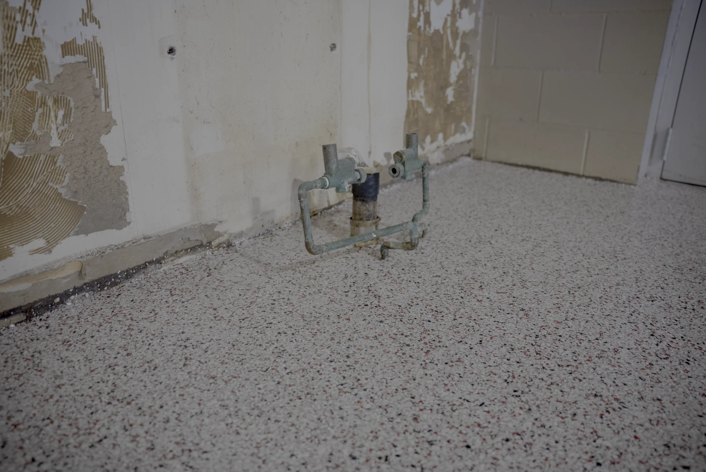Same floor drain area after restoration, now level with a polyaspartic flake finish